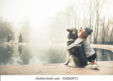 Image of young girl with her dog, alaskan malamute, outdoor