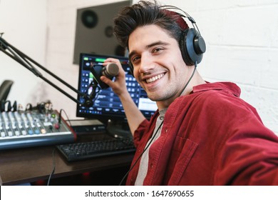 Image Of Young Happy Caucasian Dj Man Wearing Headphones Working At Radio Station While Making Podcast Recording For Online Show