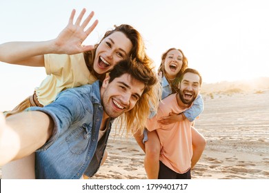 Image of young happy caucasian people smiling and taking selfie photo while walking on beach in summertime - Powered by Shutterstock