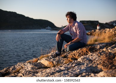 An image of a young man on the bank of a river
