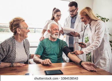 Image Of Young Medic Taking Blood Pressure During Home Visit