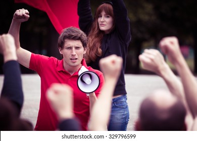 Image of young rebellious man with megaphone during street protest