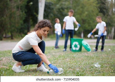 Image of young volunteers and children collecting garbage in park. Bin in park. Ecology group. Concept of environmental protection. Team with recycle project outside.
