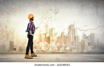 Image of young woman engineer with project against sketch background