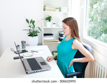 Image Of A Young Woman Having A Back Pain While Sitting At The Working Desk