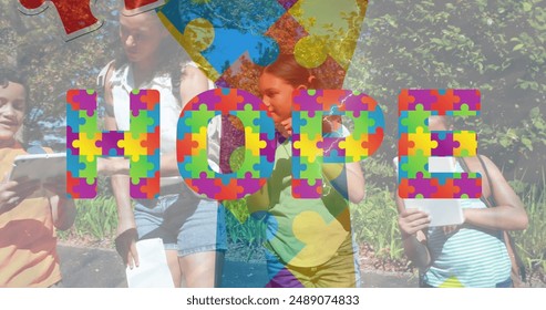 Images of colorful puzzle pieces and hope text over diverse group of children. Autism awareness concept digital generated image. - Powered by Shutterstock