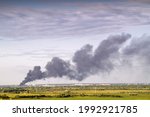 Images of smoke against the sky from a fire in the city on the horizon.