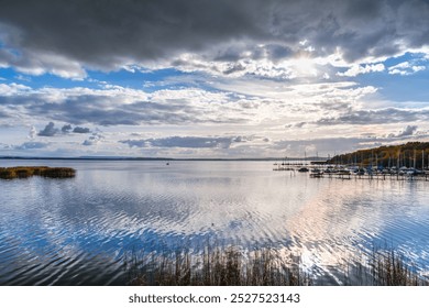 Images of Steinhuder Meer Lake showcasing its serene waters, lush greenery, and cloudy skies. The photos capture the natural beauty and tranquility of the lake, highlighting its calmness. - Powered by Shutterstock