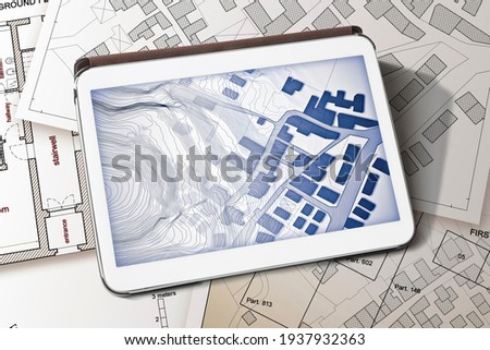 Imaginary cadastral map of territory with buildings and land parcel - concept image with a digital tablet - Note: the map background is totally invented and does not represent any real place.