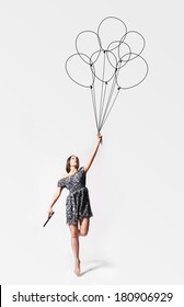 imagination. young woman is flying away with drawn balloons