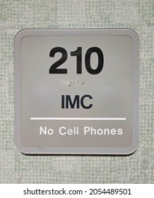 "IMC" gray numbered room sign with black letters hospital room in hospital setting