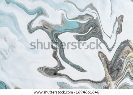 Imitation marble liquid ink. Fluid art background with light blue tints on white surface. Abstract marbling effect of acrylic paints on canvas. Magic texture with mixing colors. Modern interior design