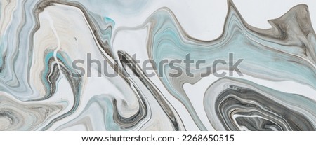 Imitation marble liquid ink. Fluid art background with light blue tints on white surface. Abstract marbling effect of acrylic paints on canvas. Magic texture with mixing colors. Modern interior design