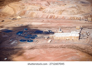 The immense scale of a copper mine and its processing plant in Chile, located in an arid environment with the open pit visible in the background.