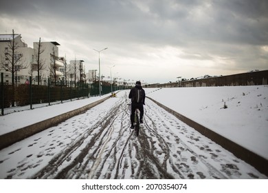 Immeretinskaya Embankment Of Sochi After A Winter Snowfall. The Cyclist Rides Through The Muddy Snow - JAN 20, 2021 SOCHI, RUSSIA