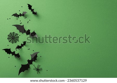 Immerse in a Halloween masterpiece! Top-down view of spooky decorations: ghastly spiders, cobweb, flying bats. Green background with confetti and an empty space for your message or promotion