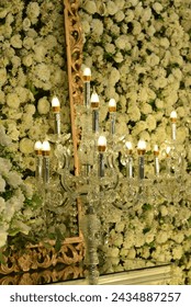 Immerse yourself in the enchantment of love with a white and pink fresh hanging flowers-themed wedding. beautiful multi-headed candle stands illuminated by warm lights.