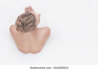 Immersed in whole body goodness. Rear view of a woman partially submerged in a white liquid.