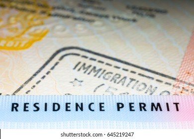 Immigration Concept Image. Residence Permit Card Over Immigration Stamp On UK Student Visa In Passport. Selective Focus