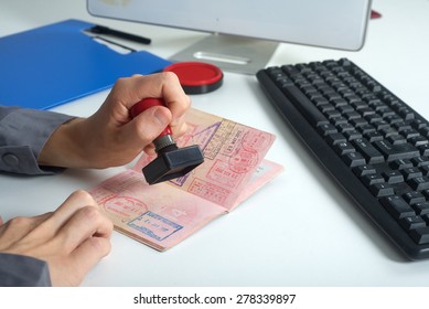 Immigration control officer will arrival stamp in the passport - Shutterstock ID 278339897