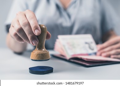 Immigration And Passport Control At The Airport. Woman Border Control Officer Puts A Stamp In The US Passport Of American Citizen. Concept 