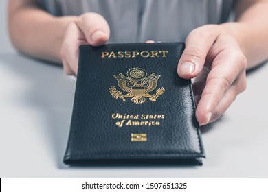 Immigration And Passport Control At The Airport. Woman Border Control Officer Puts A Stamp In The US Passport Of American Citizen. Concept 
