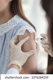 Immunization And Vaccination For Polio, Flu Shot, Influenza Or HPV Prevention With Woman Having Vaccine Shot With Syringe By Nurse For World Immunization Week And International HPV Awareness Day