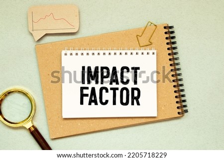 IMPACT FACTOR text written on sticky with pencil and glasses.
