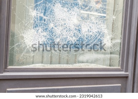 impact of stone and hammer in the window shop of the store during the strike demonstrations
