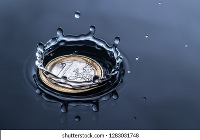 impact of a water drop splash on a euro coin in red water