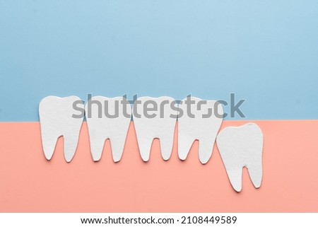 Impacted wisdom teeth with healthy tooth cartoon made from paper. Dental problems associated with wisdom teeth include tooth decay, jaw pain, oral infection or gum disease. Creative idea.