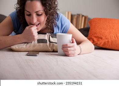 impatient girl nail-biting while she waits for a call or an answer to her chat or sms during her breakfast