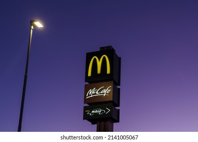 Imperia, Italien - 12. Januar 2022: McDonald's und McCafe logos außerhalb des Fastfood-Hamburger-Restaurants nachts in Imperia, Italien