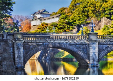 The imperial palace and garden in Japan capital city - Tokyo. Famous Nishinomaru gate with stone bridge across water-filled moat and pond leading to Omote Gozasho palace.