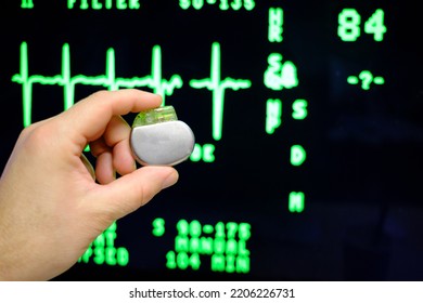 An Implantable Pacemaker Is Held In Front Of An ECG Monitor 