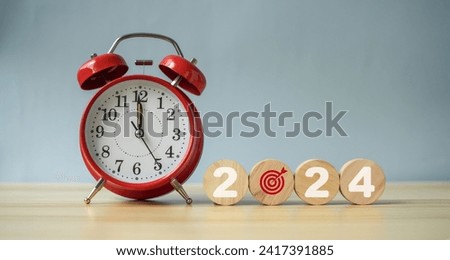 Implementation of the New Year goal plan 2024. Wooden cube with year 2024 and goal icons on green background. Business plan and development to achieve goals Target achievement and success in 2024.
