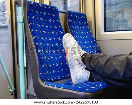 An impolite and uneducated young person placed her feet on the seat of a public tram [[stock_photo]] © 