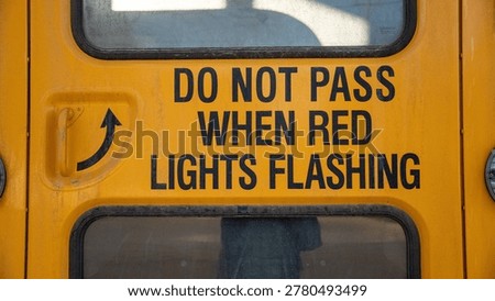 An important message on school buses reminds drivers to stop when the red light is flashing. School buses use red lights and stop signs to signal when children are boarding or alighting.