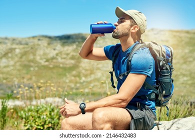 Its important to stay hydrated when hiking. Cropped shot of a young man taking a break while out on a hike. - Powered by Shutterstock