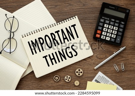 important things, top view on notebook stickers calculator and paper clips.text on page