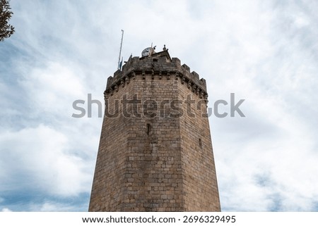Imposing heptagonal tower called the Rooster Tower or Clock Tower, in Freixo de Espada à Cinta under a cloudy sky in Portugal