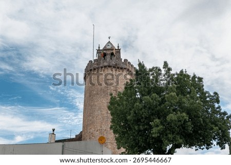 The imposing heptagonal tower of Freixo de Espada à Cinta Castle, also known as Torre do Galo or Torre do Relógio, stands out against a partly cloudy sky in Trás-os-Montes, Portugal