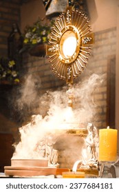 An imposing monstrance, with gleaming rays, is the abode of the Body of Christ, present in the consecrated host. The monstrance stands majestic, with Christ at the center of its golden splendor.