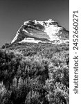 Imposing Sandstone Cliff with a small arch in black and white in the Drakensberg Mountains of South Africa