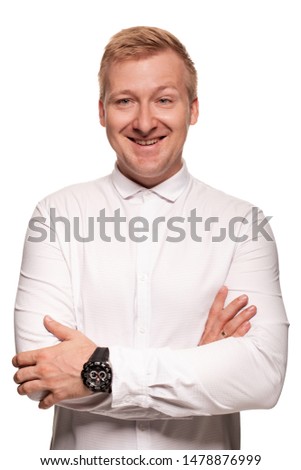 Imposing, young, blond man in a white shirt is grimacing while standing isolated on a white background