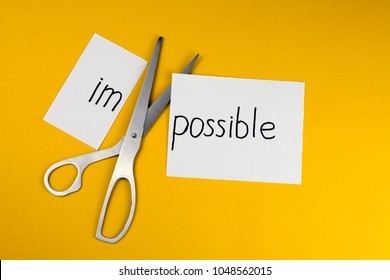 Impossible Is Possible Concept. card with the text impossible, cutting the word im so it written possible. 