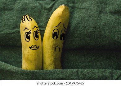 Impotence, Lack Of Attraction To His Wife, Sexual Coldness. Two Bananas, Spouses, In A Family Bed. The Woman Flirts, Her Husband Turns Away. The Picture Is Made By The Author.