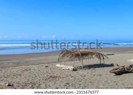 A impoverished parasol mada of palm branches on the sandy beach of the Pacificocean 