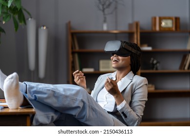 Impressed Amazed African American Female Freelancer Trying VR Headset At First Time To Relax After Working Day From Home, Excited Black Woman Shocked How Virtual Reality Could Improve Remote Work