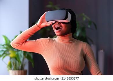 Impressed black woman with drop jaw using virtual reality headset, getting immersed experience, stanned african female interacting with immersive digital world, testing VR technology for business - Powered by Shutterstock